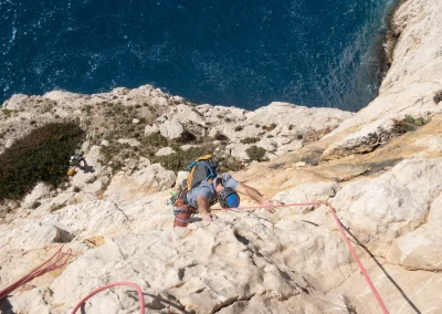 Un grimpeur dans la grande voie l'Aube au Cancéou dans les calanques - © Florian Garibal