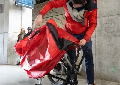 Un homme met son vélo sous housse pour le prendre dans le train - © Florian Garibal